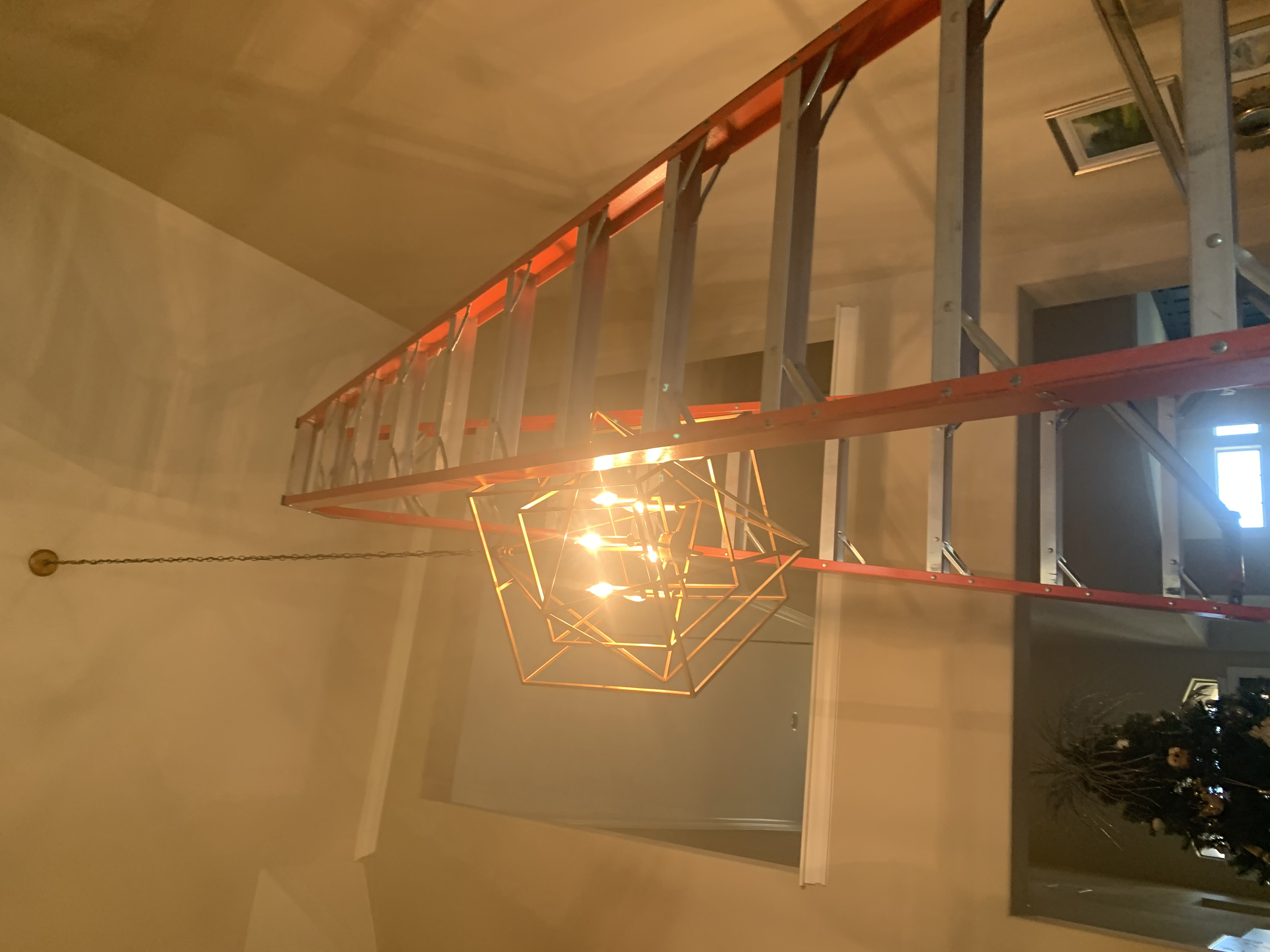 Chandelier installation in high ceiling home